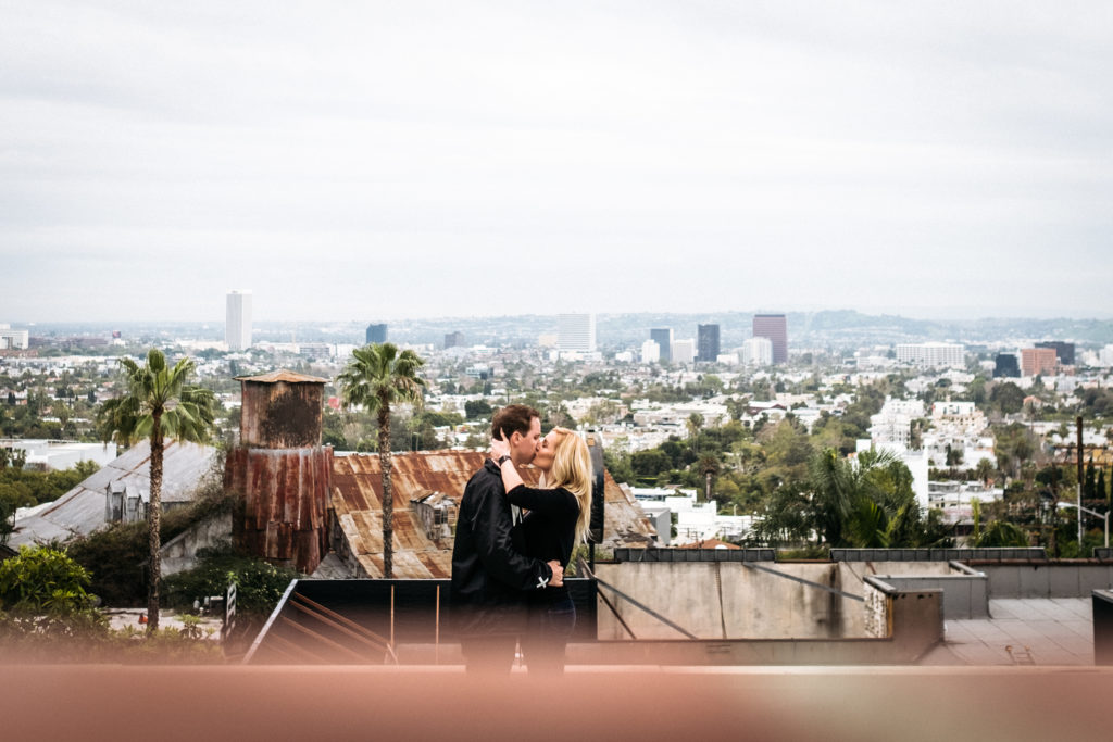 Engagement photo on a rooftop with a view of Downtown Los Angeles, California
