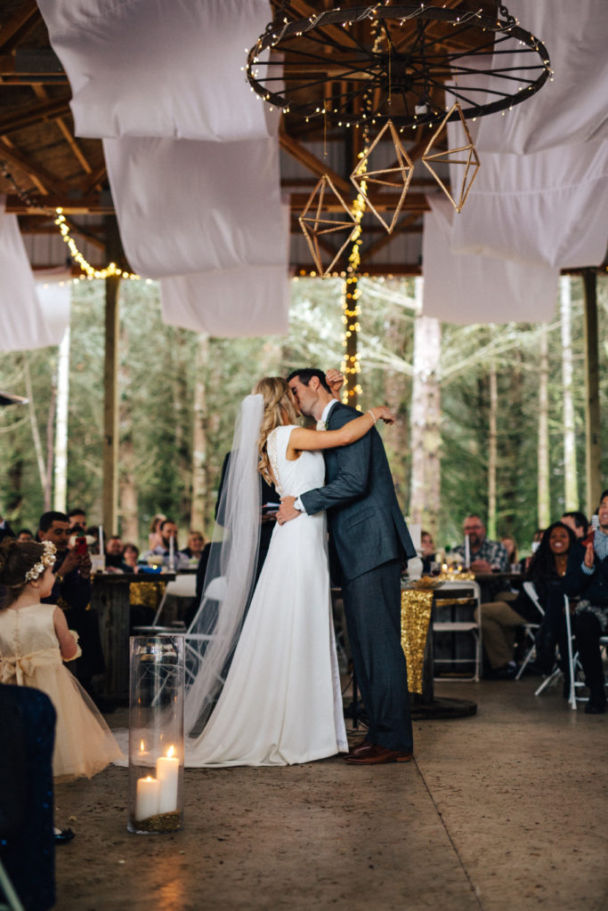 A bride and grooms first kiss during their wedding ceremony at Home Place Farm in Molalla, Oregon