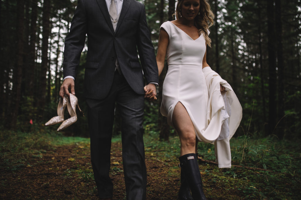 Bride and groom walking in the rain wearing Hunter boots at Home Place Farm