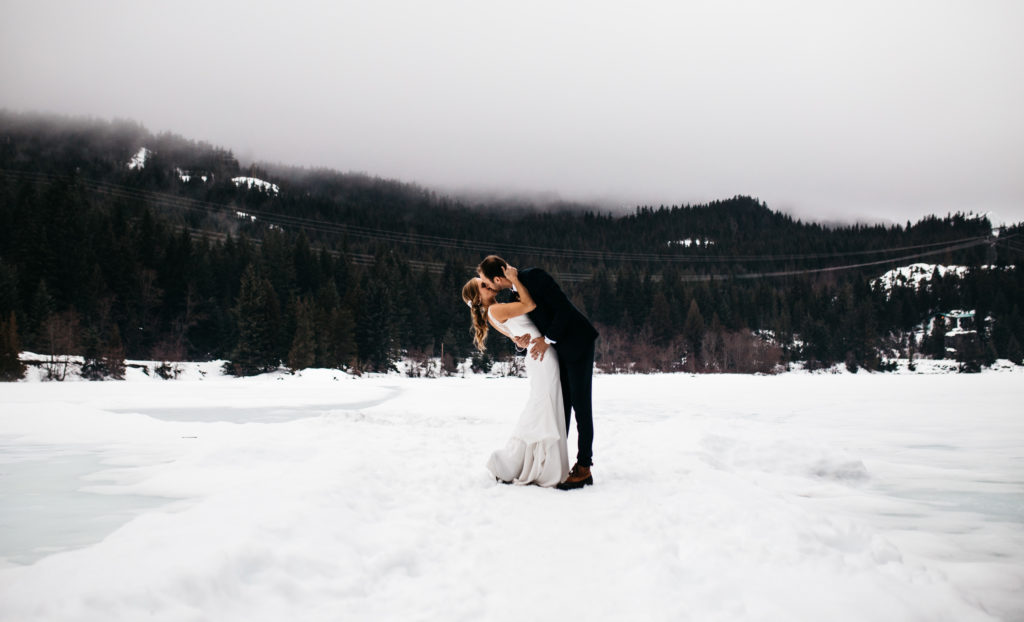 Bride and groom on a frozen lake at their winter wedding in Whistler