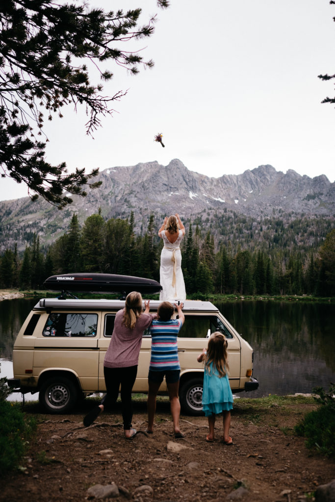 Bride tossing her bouquet on top of a mountain in Montana