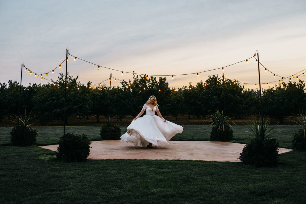 A bride spinning in her dress at sunset at Postlewait's country weddings in Canby, OR