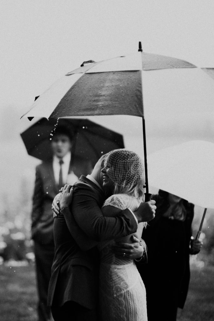 First kiss in the rain at Scholls Valley Lodge wedding