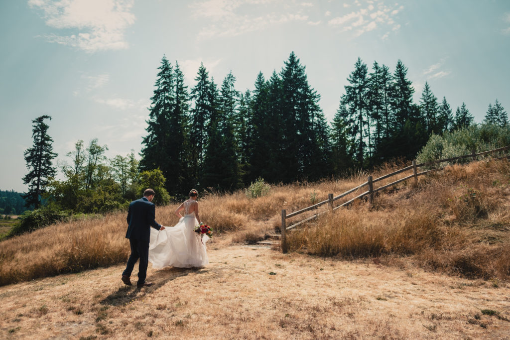 Bride and groom walking across the lawn at Fireseed Catering on Whidbey Island