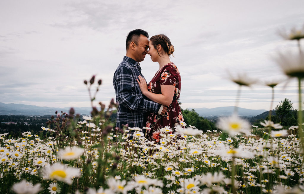 Engagment photo at Powell Butte Nature Park in a field of daisies