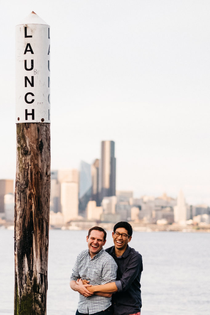 Engagement photo overlooking downtown Seattle on Alki Beach