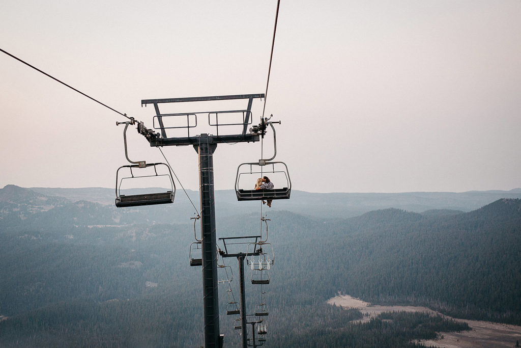 Engagement photo of a couple kissing on the ski lift on Mount Bachelor in Bend, Oregon