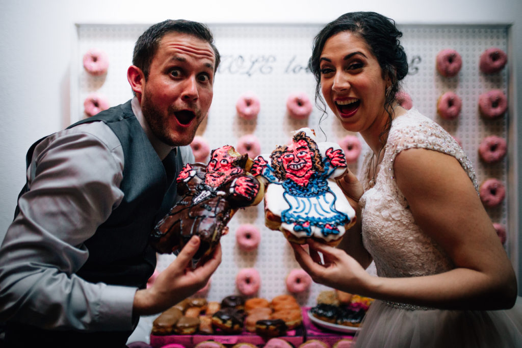Bride and groom with their voodoo donuts wedding donuts