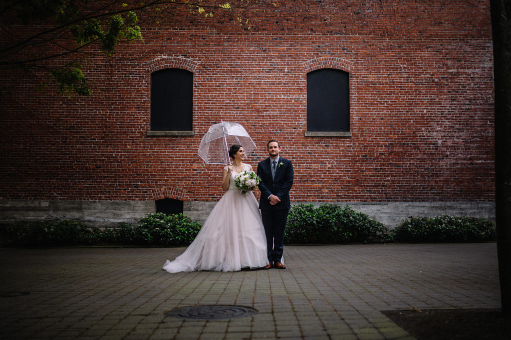 Bride and groom in the rain with an umbrella in Portland, OR