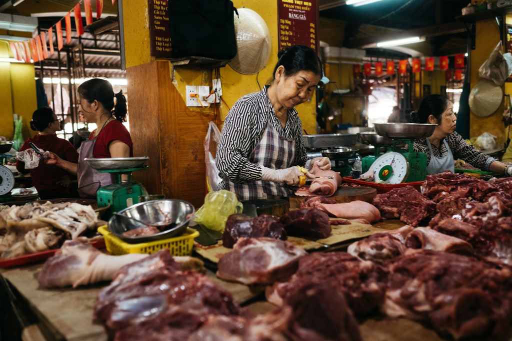 Women butchering meat at the central market in Hoi An, Vietnam
