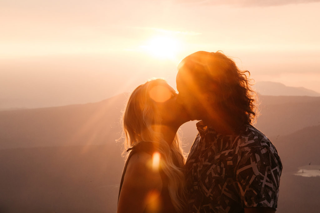 Engagement photo at sunset with a lens flare on Mount Bachelor