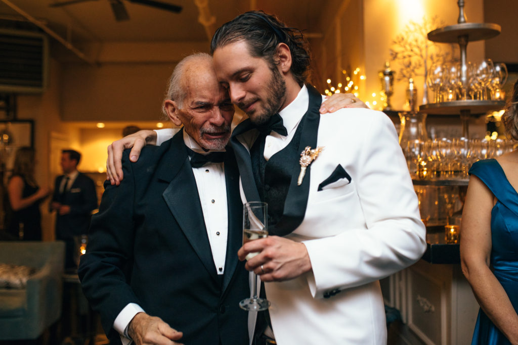 Candid moment of a groom and his father at the Elysian Ballroom