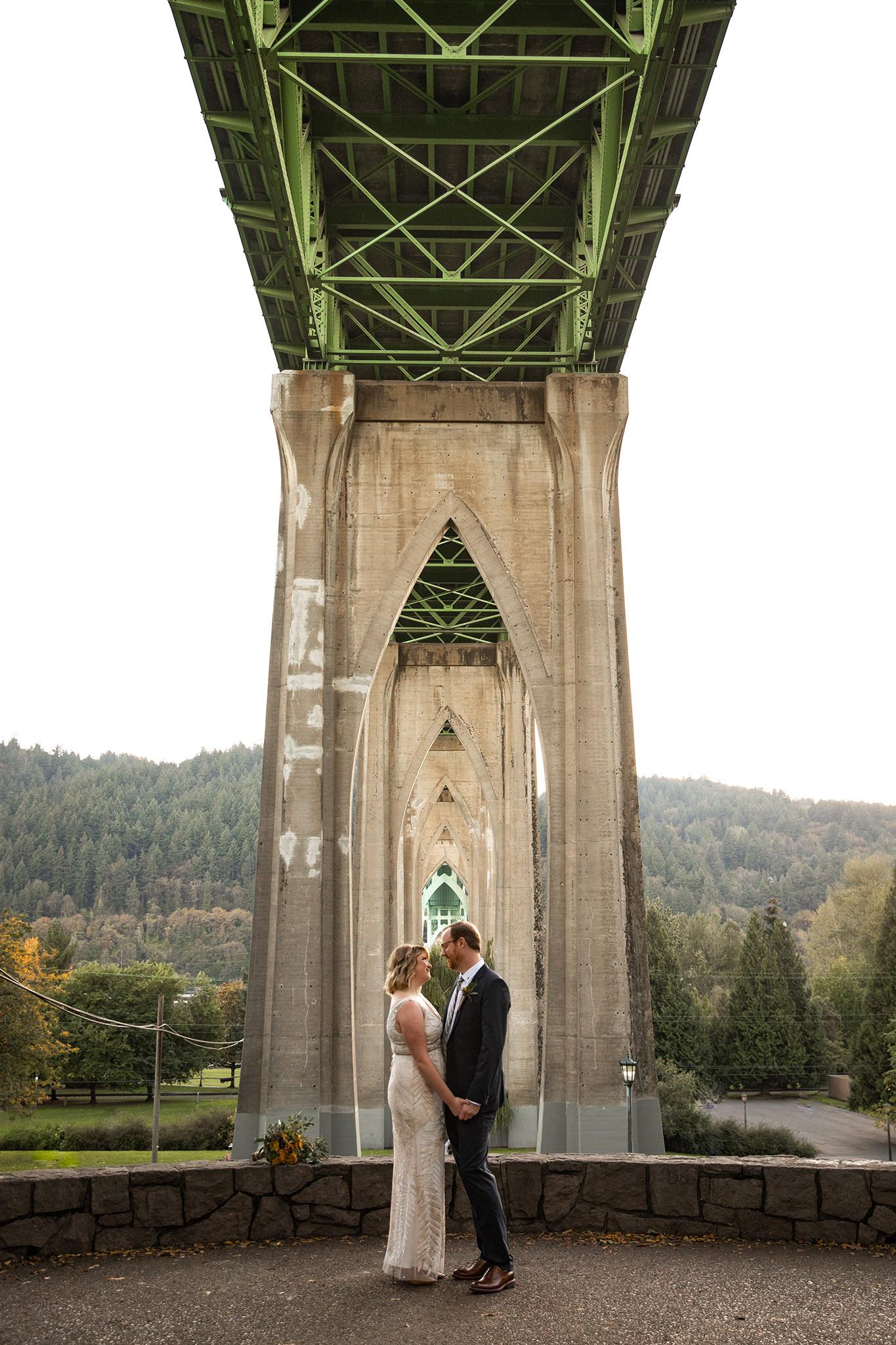 A wedding photo beneath the St. John's Bridge at Cathedral Park in Portland