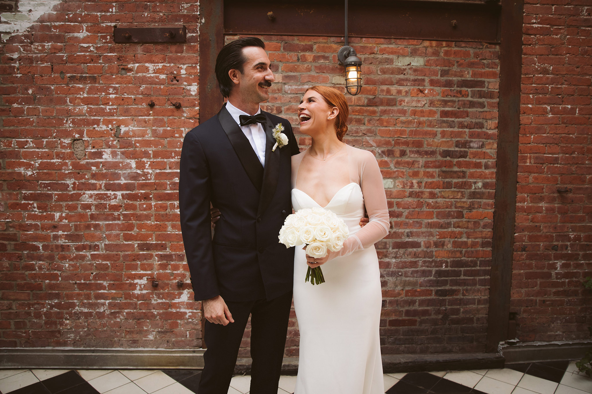 An industrial wedding portrait in front of a brick wall at the Wythe Hotel
