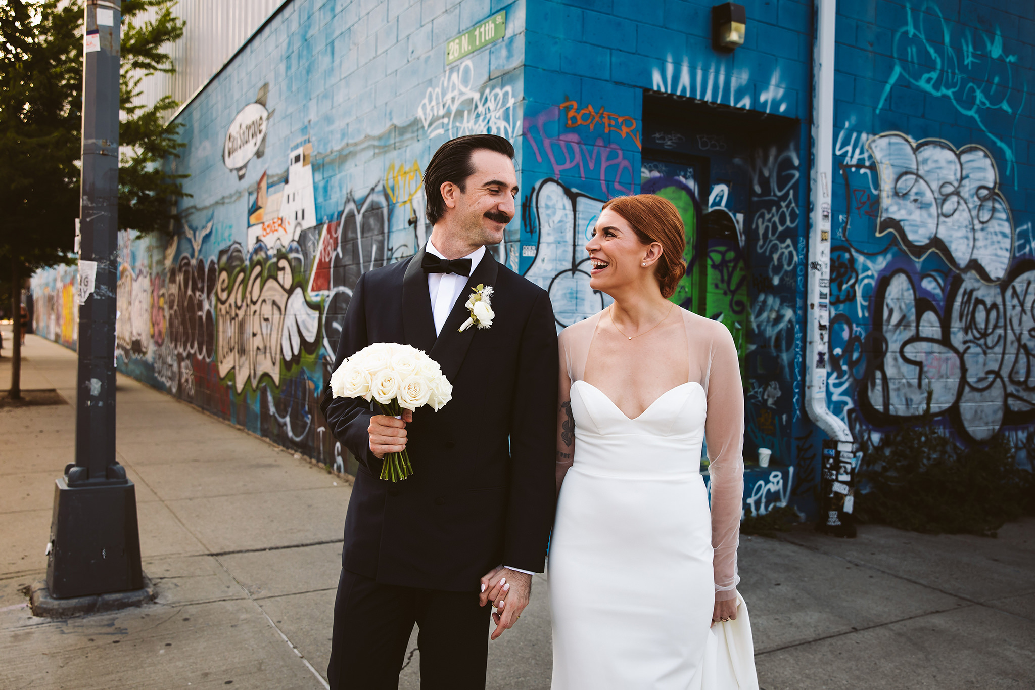 A wedding photo with street art and graffiti in the background in Brooklyn, New York