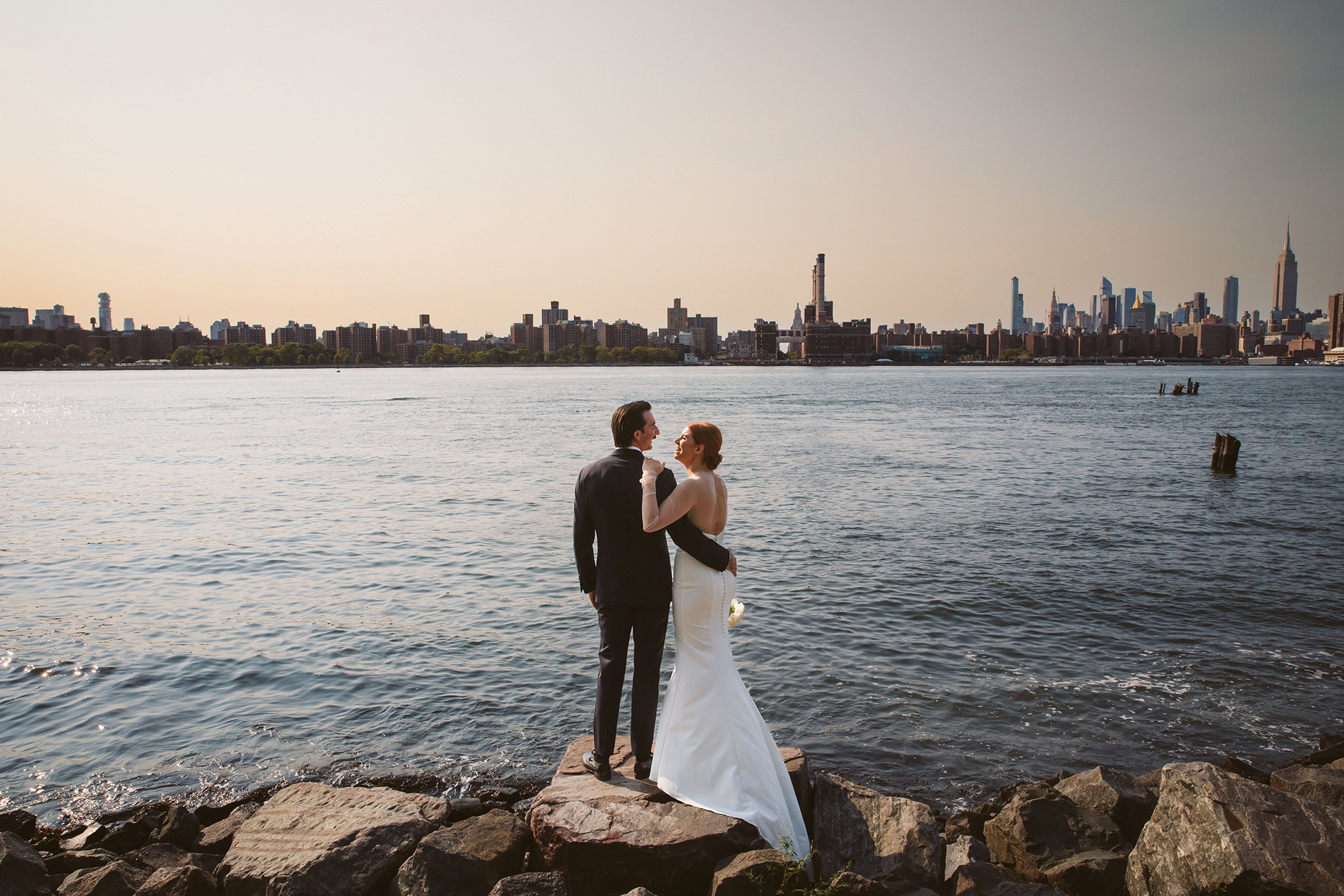 Wedding photo of a bride and groom next to the East River in New York