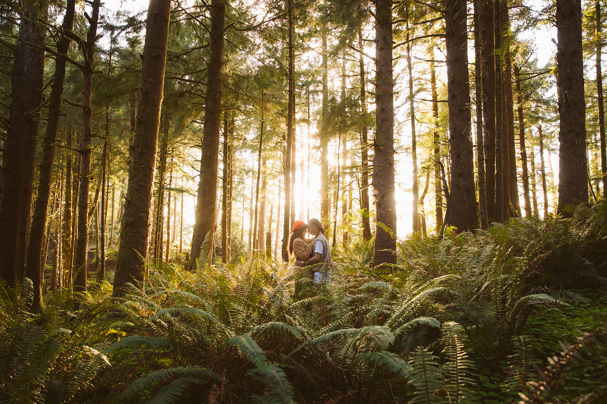 A couple in the forest on the Oregon coast during their engagement session