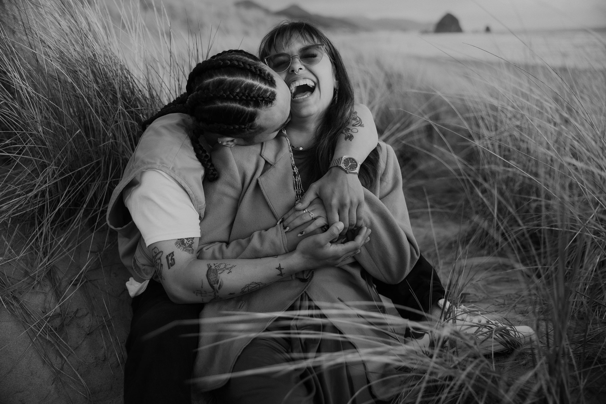 A candid black and white Cannon Beach engagement photo in the sand dunes