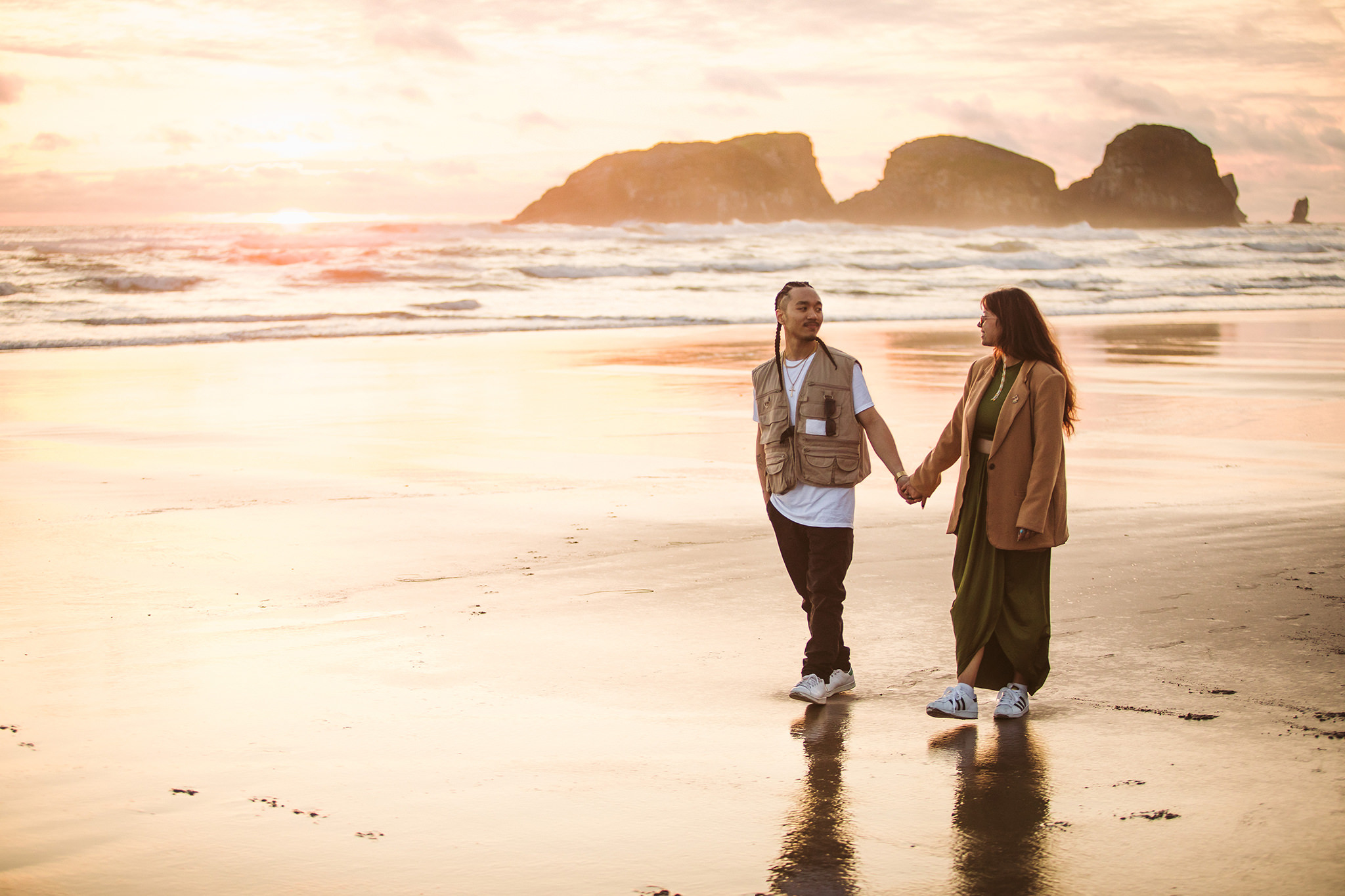 A couple walking along Cannon Beach during their engagement session