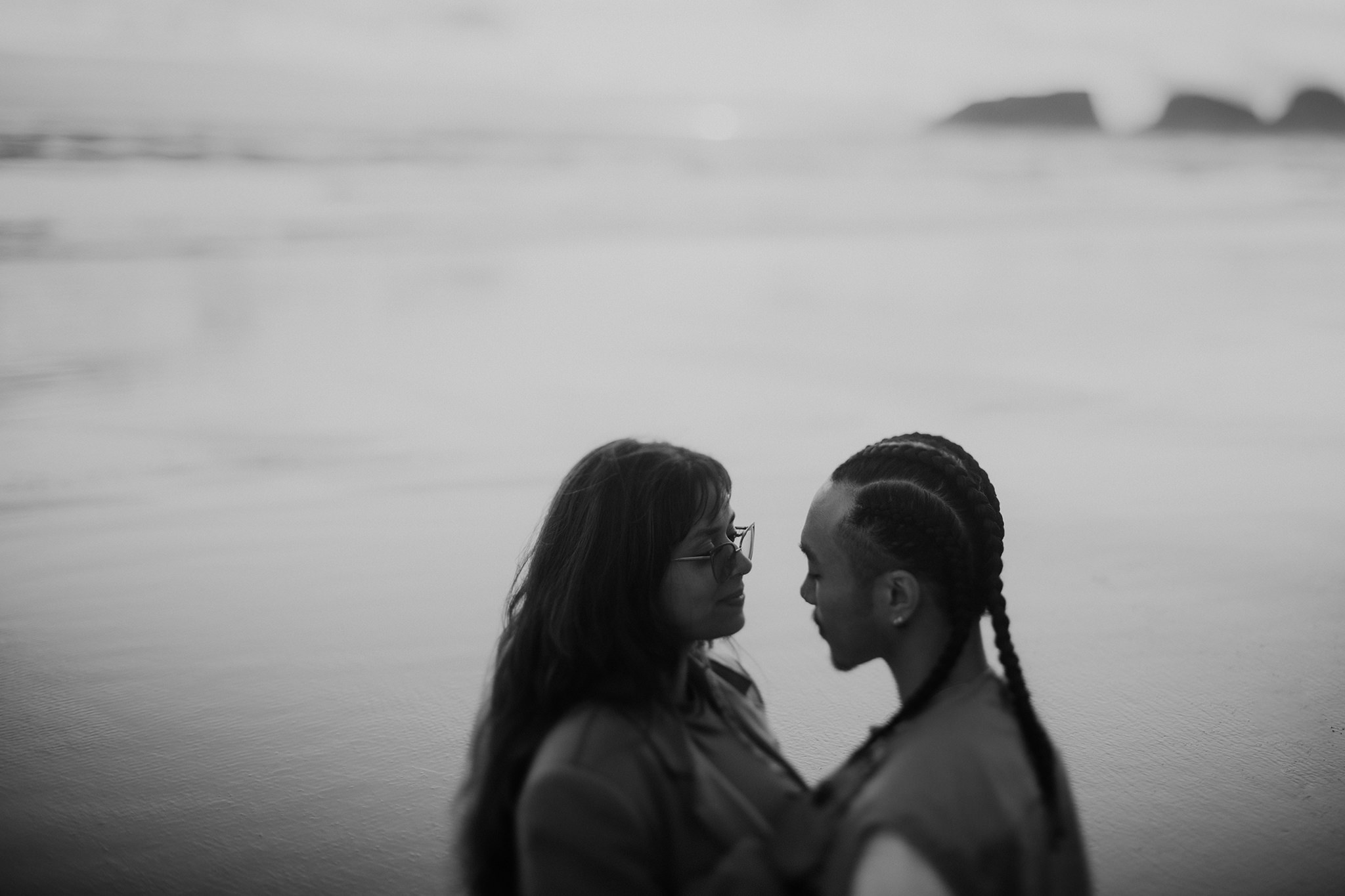 A moody black and white engagement photo on the Oregon coast