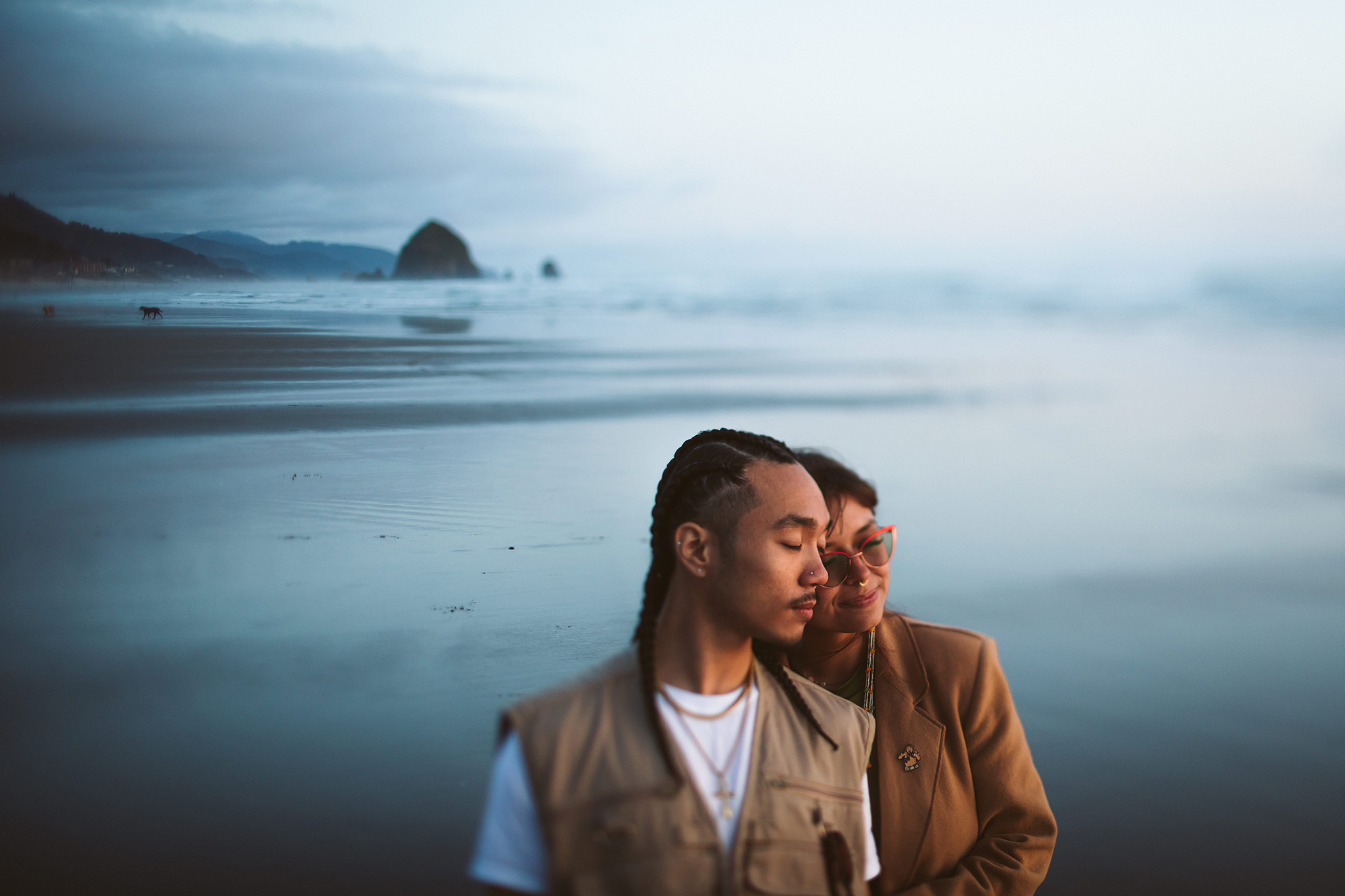 A moody engagement photo at dusk on Cannon Beach