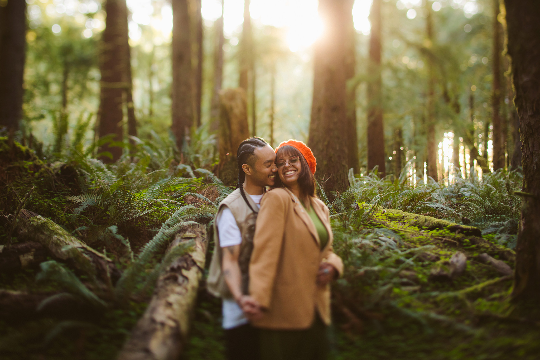 An engagement photo in the ferns at golden hour on the Oregon coast near Cannon Beach