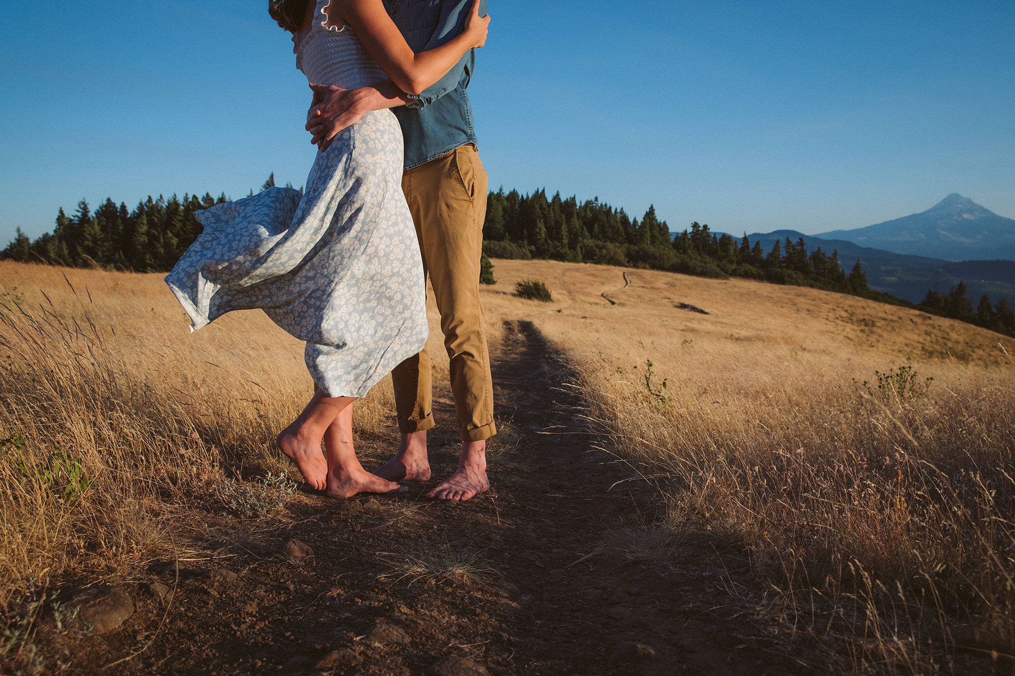 A windy summer engagement photo with Mount Hood in the background