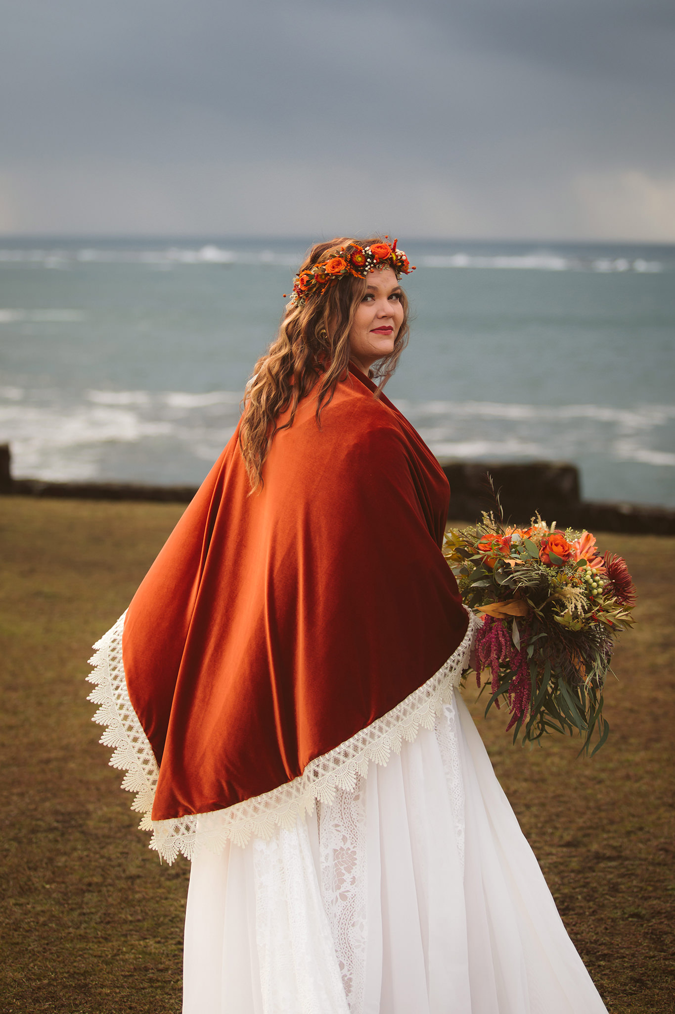 A bride on a cliff with the ocean in the background at her shore acres state park elopement