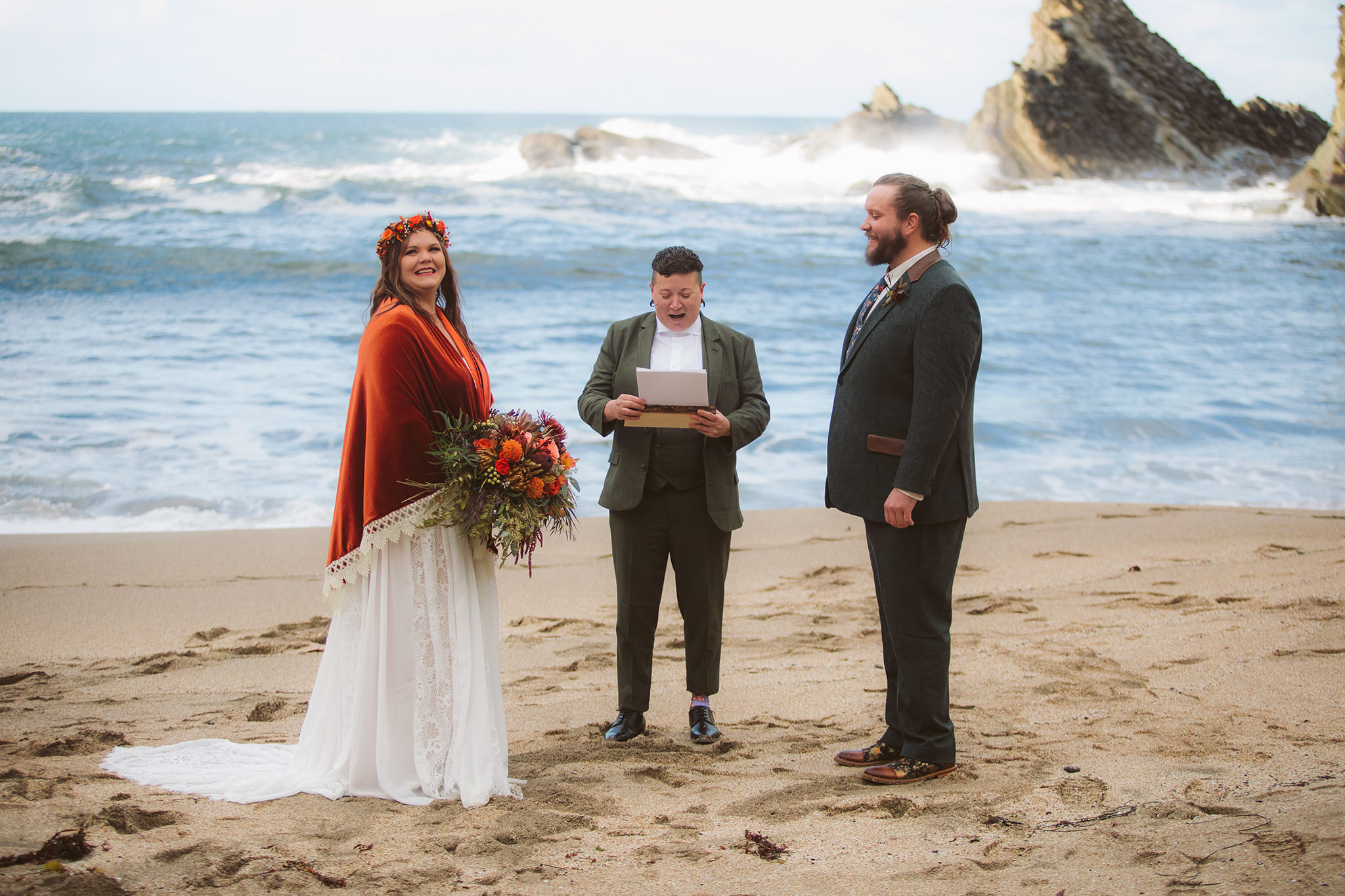 Water crashing into the cliffs during an elopement ceremony on the beach at Shore Acres state park in Coos Bay, Oregon