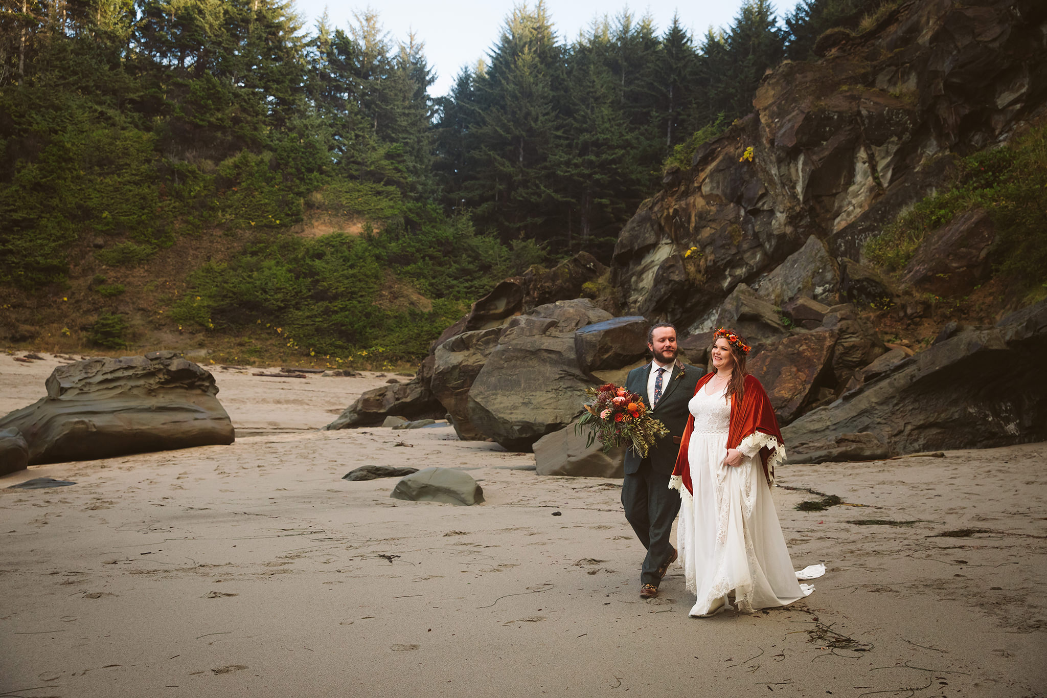 A bride and groom walking on a Pacific Northwest beach in Oregon