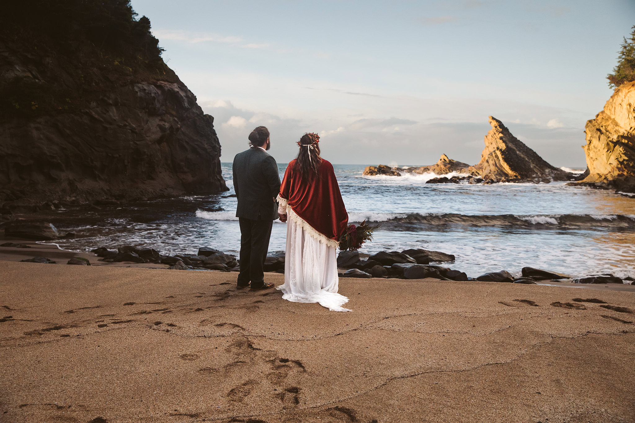 A bride and groom looking out at the ocean